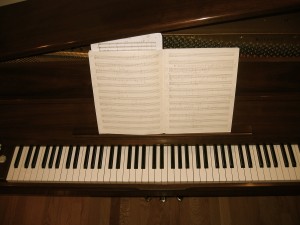 piano keyboard with sheets of music